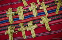 Palm fronds weaved into crosses lay for sale at a Palm Sunday Mass in El Alto, Bolivia, Sunday, April 13, 2014. For Christians, Palm Sunday marks Jesus Christ's entrance into Jerusalem, when his followers laid palm branches in his path, prior to his crucifixion. (AP Photo/Juan Karita)