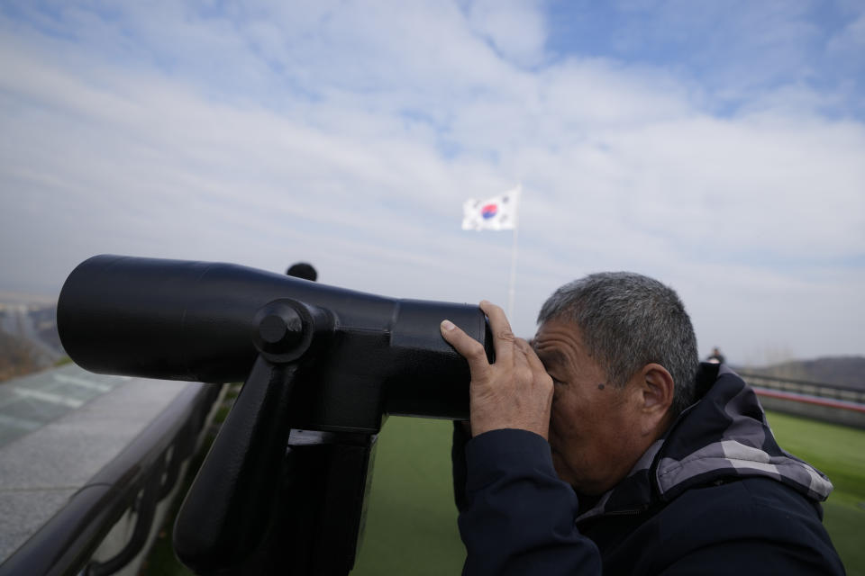 A visitor uses a pair of binoculars to see the North Korean side from the unification observatory, in Paju, South Korea, Wednesday, Nov. 22, 2023. South Korea will partially suspend an inter-Korean agreement Wednesday to restart frontline aerial surveillance of North Korea, after the North said it launched a military spy satellite in violation of United Nations bans, Seoul officials said. (AP Photo/Lee Jin-man)