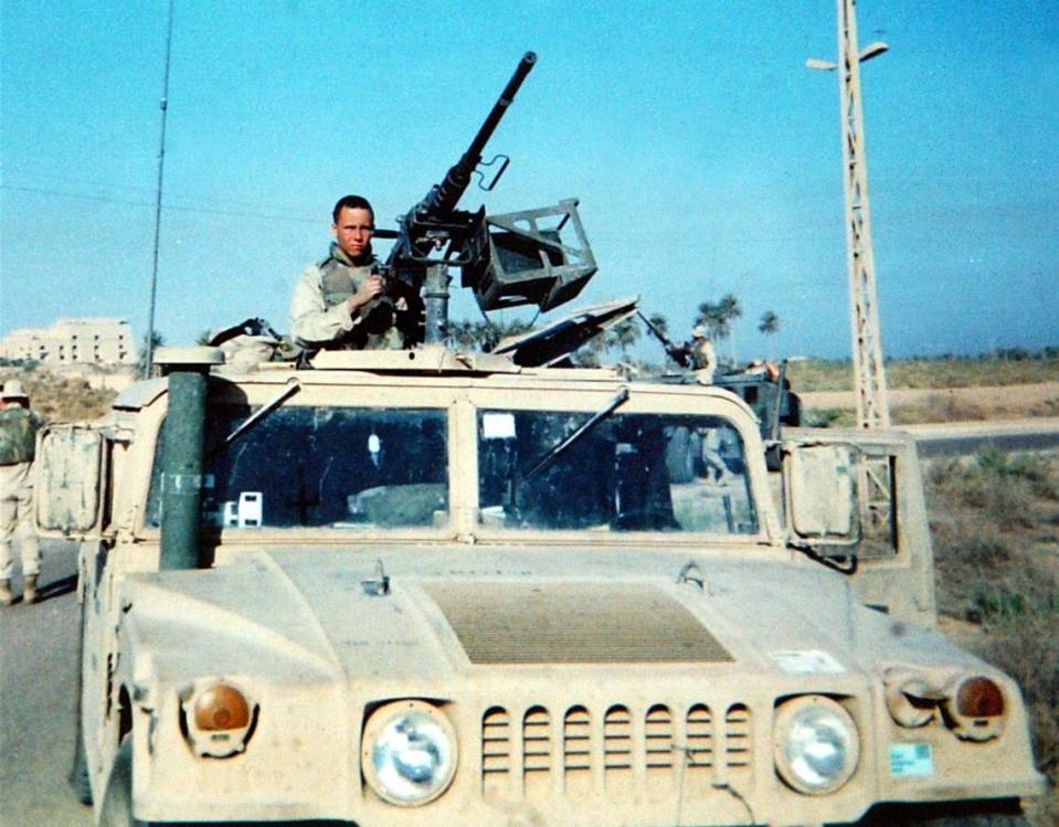 Lance Cpl. Scott Dougherty of the United States Marine Corps is photographed atop a HUMVEE during his last tour of duty in Iraq.