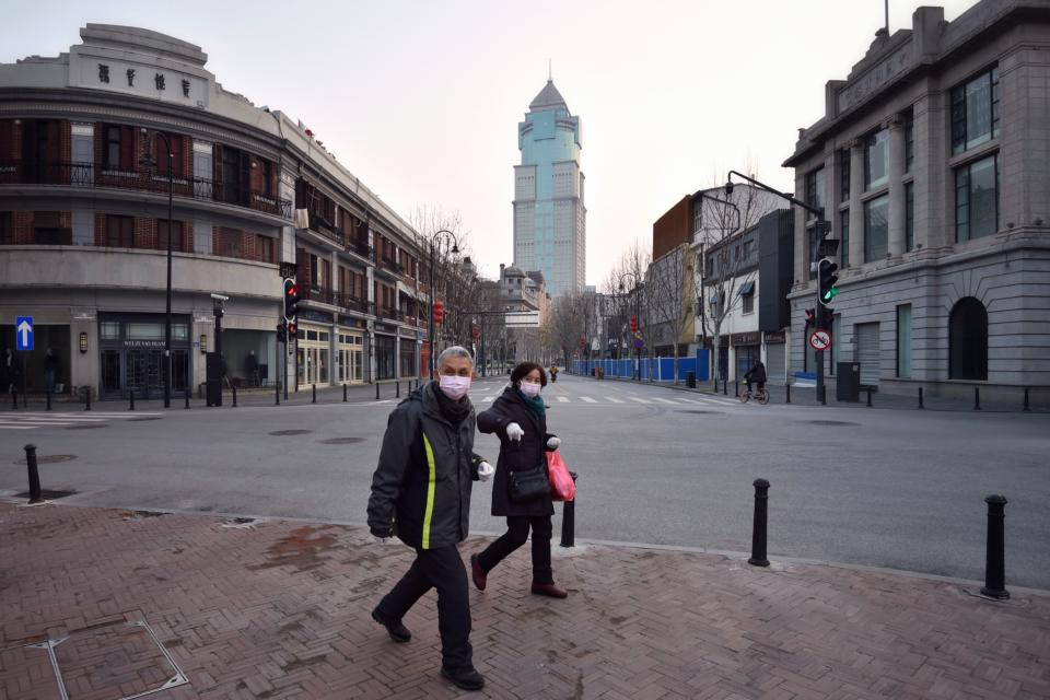 WUHAN, CHINA - FEBRUARY 21 2020: Masked people walk in the empty street due to the lockdown to curb the COVID epidemic in Wuhan in central China's Hubei province Friday, Feb. 21, 2020.- PHOTOGRAPH BY Feature China / Barcroft Studios / Future Publishing (Photo credit should read Feature China/Barcroft Media via Getty Images)