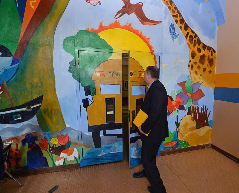 Randy Pruchnicki opens a door covered in a mural at Irving Elementary School in Erie on June 30, 2017, shortly after the Erie School District put Irving and its other unused buildings up for sale. Pruchnicki handles real estate matters for the Erie School District as its director of non-instructional support services for the Erie School District.