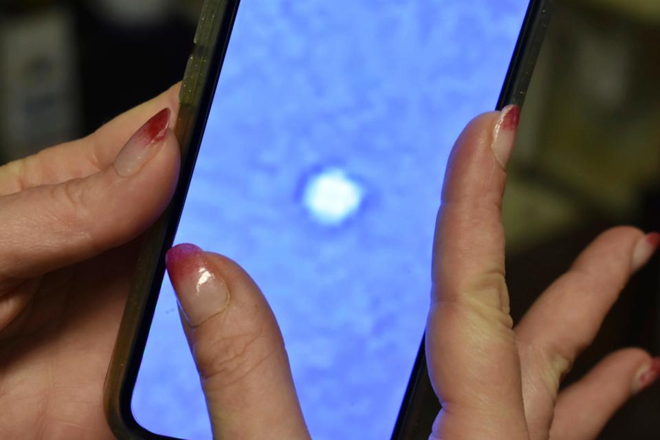 Lindsay McDonald holds up a photo she took of an orb over central Montana that's believed to be a suspected Chinese spy balloon, Feb. 7, 2023.