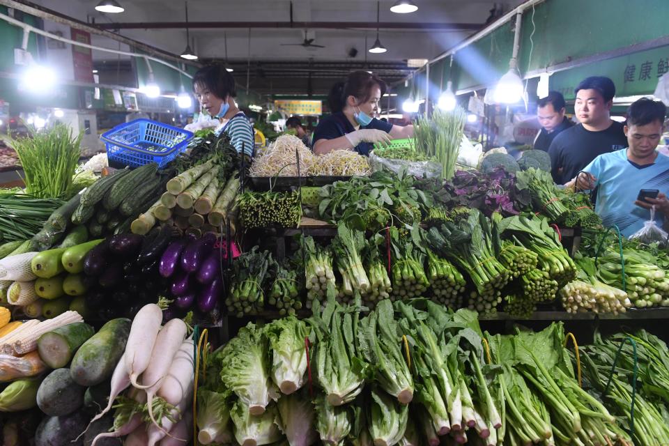 People shop for vegetables at a market in Nanning, capital of south China's Guangxi Zhuang Autonomous Region, July 9, 2022. China's consumer price index CPI, a main gauge of inflation, rose 2.5 percent year on year in June, according to data released by the National Bureau of Statistics NBS on Saturday. (Photo by Lu Boan/Xinhua via Getty Images)