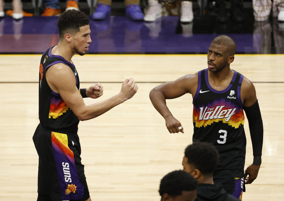 PHOENIX, ARIZONA - JULY 08: Devin Booker #1 of the Phoenix Suns celebrates with Chris Paul #3 against the Milwaukee Bucks during the first half in Game Two of the NBA Finals at Phoenix Suns Arena on July 08, 2021 in Phoenix, Arizona. NOTE TO USER: User expressly acknowledges and agrees that, by downloading and or using this photograph, User is consenting to the terms and conditions of the Getty Images License Agreement. (Photo by Christian Petersen/Getty Images)