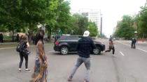 A protester runs as a vehicle speeds through a protest in Denver held following the death of George Floyd in Minneapolis