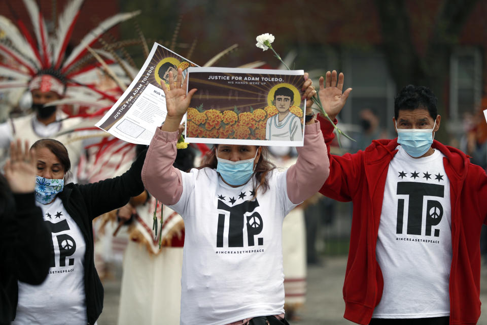 Demonstrators raise their hand as they attend a peace walk honoring the life of police shooting victim 13-year-old Adam Toledo, Sunday, April 18, 2021, in Chicago's Little Village neighborhood. (AP Photo/Shafkat Anowar)