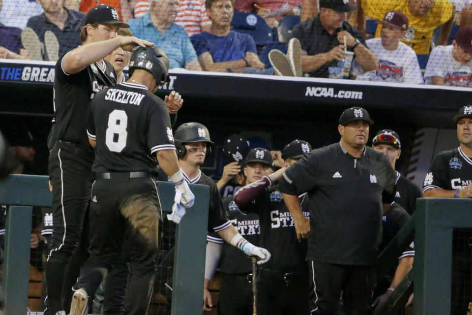 Mississippi State's Dustin Skelton (8) is greeted at the dugout after he scored against Auburn on an RBI single by Gunner Halter in the sixth inning of an NCAA College World Series baseball game in Omaha, Neb., Sunday, June 16, 2019. (AP Photo/Nati Harnik)