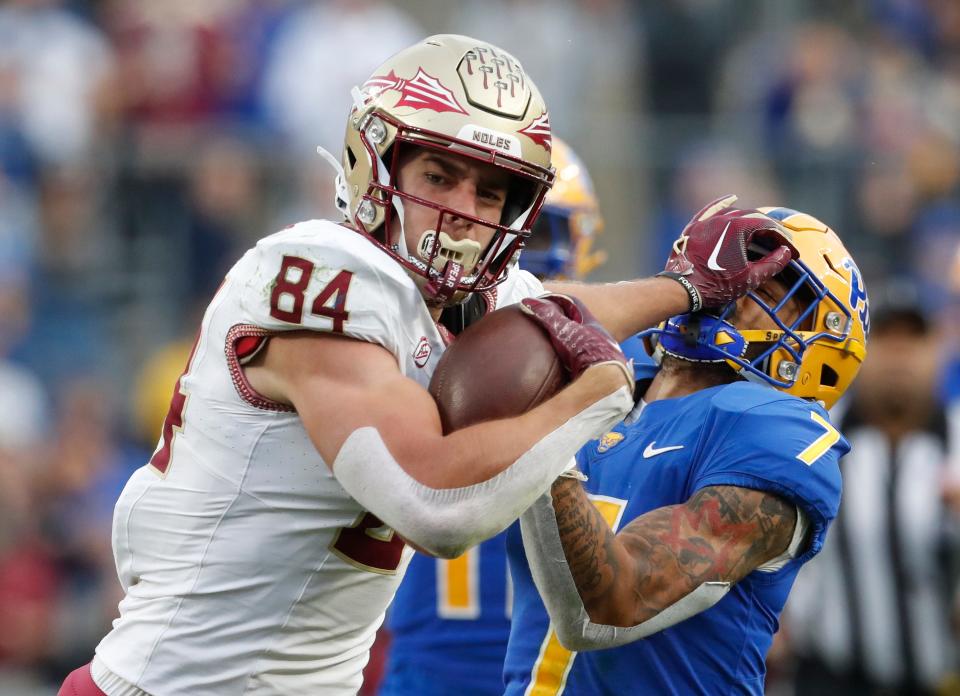 Florida State Seminoles tight end Kyle Morlock (84) stiff arms Pittsburgh Panthers defensive back Javon McIntyre (7) after a catch during the second quarter Nov. 4, 2023, at Acrisure Stadium in Pittsburgh, Pennsylvania.