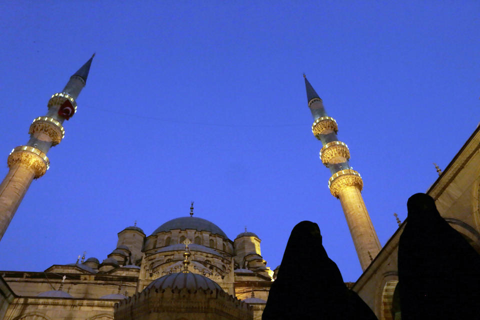 Women walk at the Eminonu Mosque in Istanbul