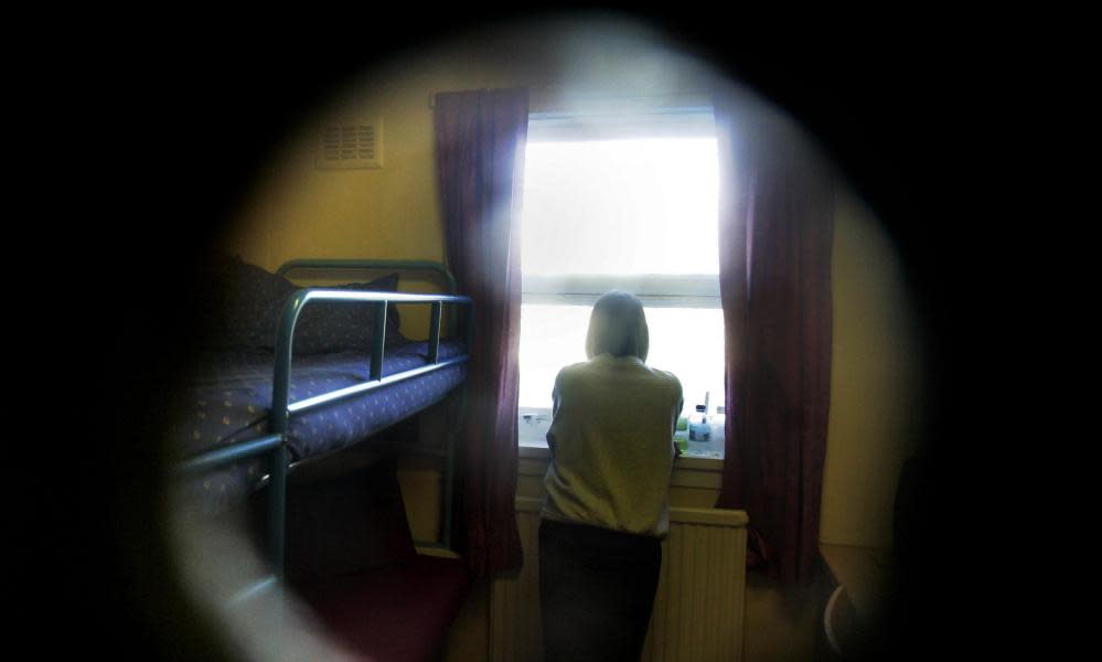 female prisoner seen through the door of her cell