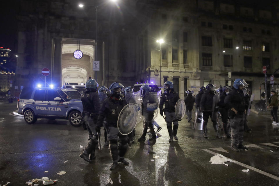 Police patrol outside the central train station, during a protest against the government restriction measures to curb the spread of COVID-19, in Milan Italy, Monday, Oct. 26, 2020. Italy's leader has imposed at least a month of new restrictions to fight rising coronavirus infections, shutting down gyms, pools and movie theaters and putting an early curfew on cafes and restaurants. (AP Photo/Luca Bruno)