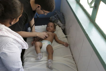 A child suspected to be infected with Zika virus is being examined by a doctor at the emergency room in a hospital at the Petare slum in Caracas, Venezuela February 4, 2016. REUTERS/Marco Bello