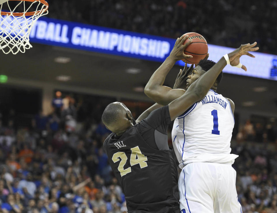 Duke's Zion Williamson (1) shoots while defended by Central Florida's Tacko Fall (24) during the second half of a second round men's college basketball game in the NCAA Tournament in Columbia, S.C. Sunday, March 24, 2019. (AP Photo/Richard Shiro)