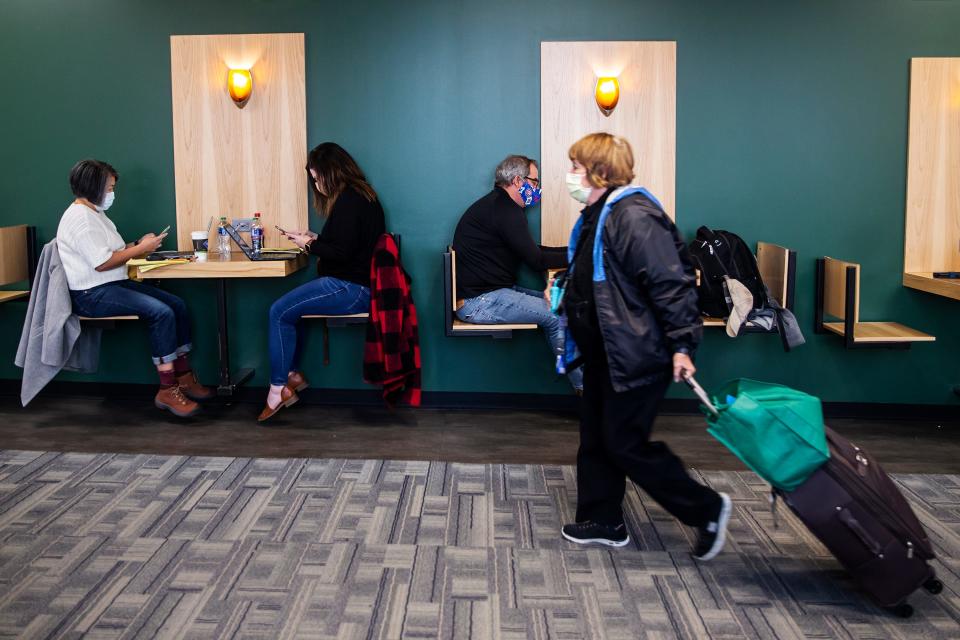 Travelers wait for their flights at the Des Moines International Airport, on Thursday, Nov. 18, 2021, in Des Moines. 