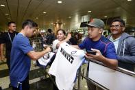 <p>Yuto Nagatomo of Inter Milan signs autograph for fans after arriving at Changi International Airport </p>