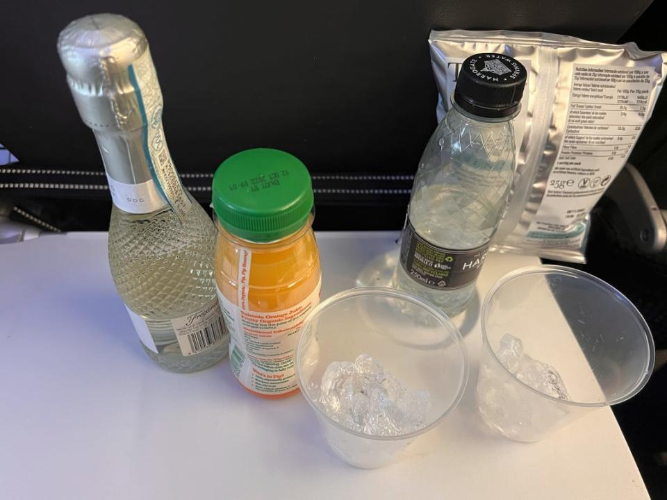 Picture showing a bottle of Prosecco, orange juice, and flat water.