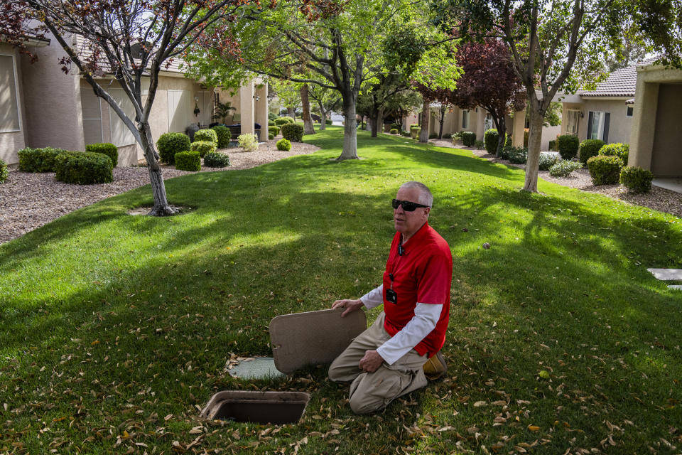 El gerente de instalaciones, Larry Fossan, se pone de rodillas sobre un prado que tienen programado retirar en Sun City Anthem, en Henderson, Nevada, el 28 de marzo de 2022. (Joe Buglewicz/The New York Times)