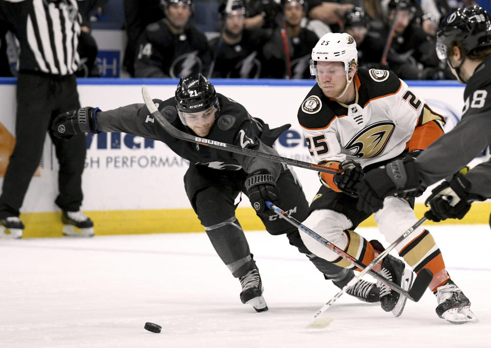 Tampa Bay Lightning center Brayden Point (21) and Anaheim Ducks right wing Ondrej Kase (25) battle for the puck during the first period of an NHL hockey game Saturday, Nov. 23, 2019, in Tampa, Fla. (AP Photo/Jason Behnken)
