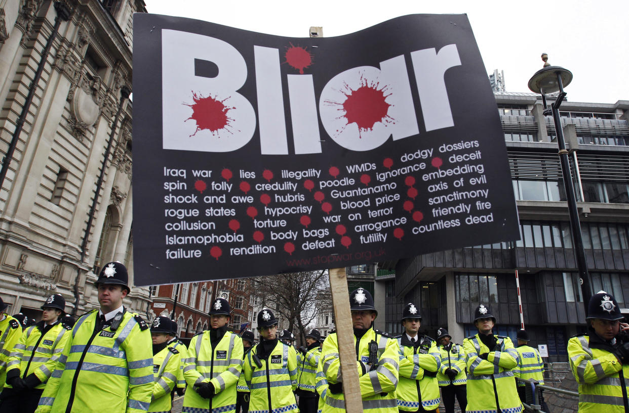 Demonstrators wave placards in front of police during a protest, as Britain's former Prime Minister, Tony Blair, gives evidence to the Iraq Inquiry, in London, January 29, 2010. Protesters chanting 