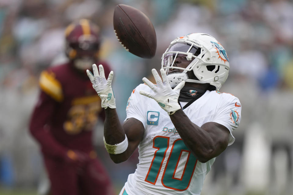 Miami Dolphins wide receiver Tyreek Hill (10) catches a touchdown pass during the first half of an NFL football game against the Washington Commanders Sunday, Dec. 3, 2023, in Landover, Md. (AP Photo/Mark Schiefelbein)