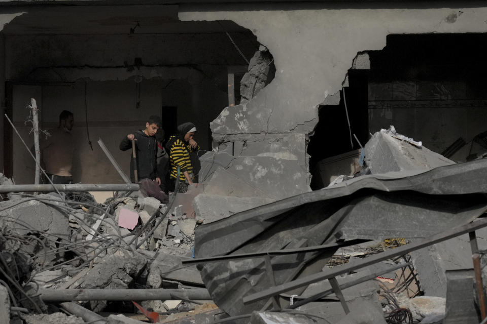 Palestinians stand in their home destroyed in the Israeli bombardment of Al Zawayda, central Gaza Strip, on Sunday, Dec. 10, 2023. (AP Photo/Hatem Moussa)