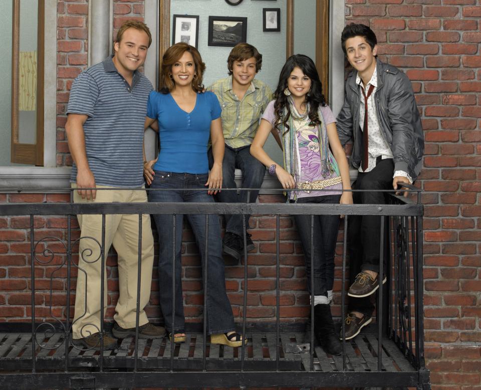 The cast of Wizards of Waverly Place stand on a fire escape