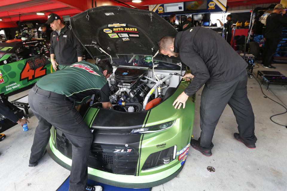 The crew for Chase Elliott work on his car in the garage at Martinsville Speedway In Martinsville, Va., Saturday, Oct. 26, 2019. Elliott had an engine failure less than five minutes into the opening practice for the third round of NASCAR's playoffs. (AP Photo/Steve Helber)