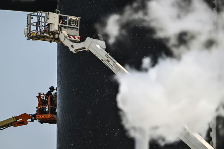 Des personnes travaillent sur la fusée Starship près de la rampe de lancement avant son quatrième vol d'essai depuis la base spatiale Starbase de SpaceX à Boca Chica, au Texas, le 4 juin 2024 (CHANDAN KHANNA)