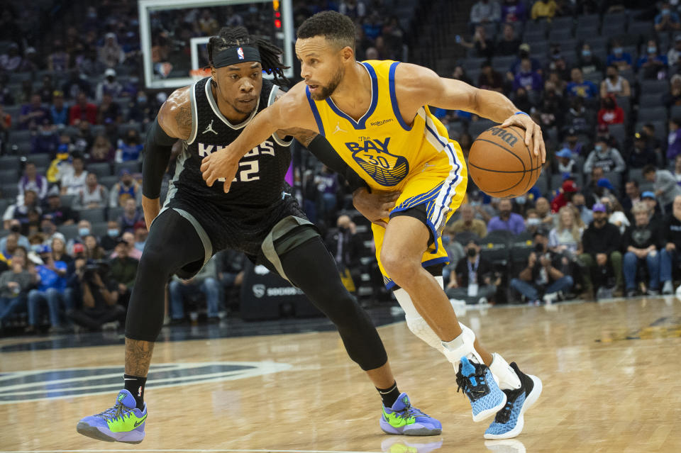 Sacramento Kings center Richaun Holmes (22) guards Golden State Warriors guard Stephen Curry (30) during the first quarter of an NBA basketball game in Sacramento, Calif., Sunday, Oct. 24, 2021. (AP Photo/Randall Benton)