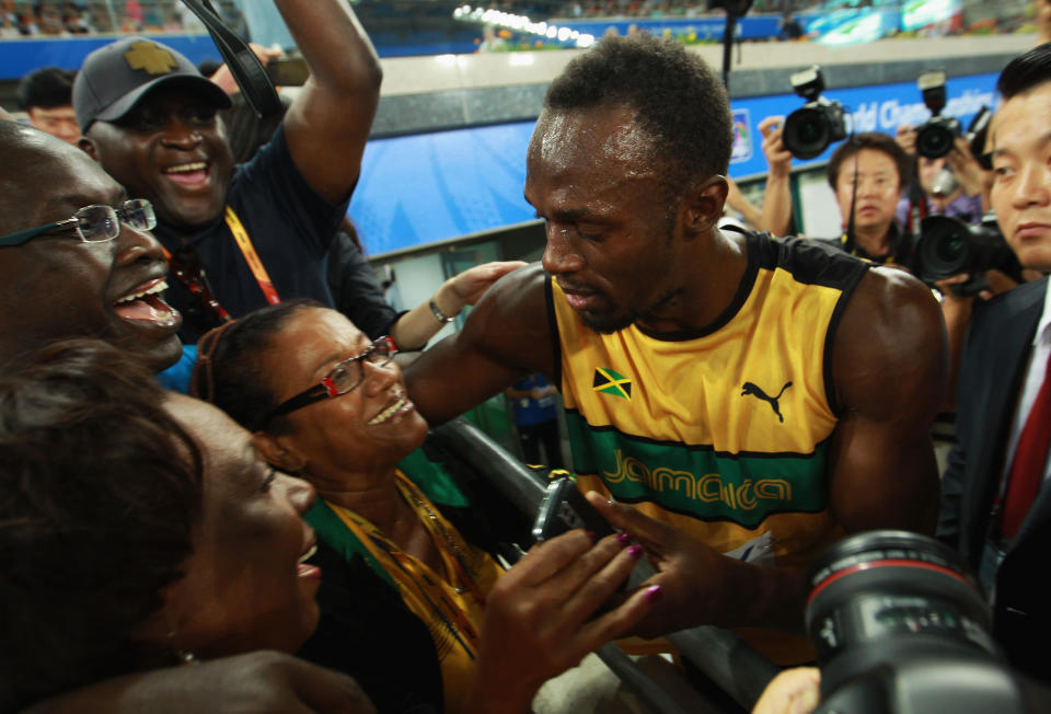 Usain Bolt of Jamaica celebrates victory and a new world record with his mother Jennifer Bolt following the men's 4x100 metres relay final during day nine of 13th IAAF World Athletics Championships at Daegu Stadium on September 4, 2011 in Daegu, South Korea. (Photo by Alexander Hassenstein/Bongarts/Getty Images)