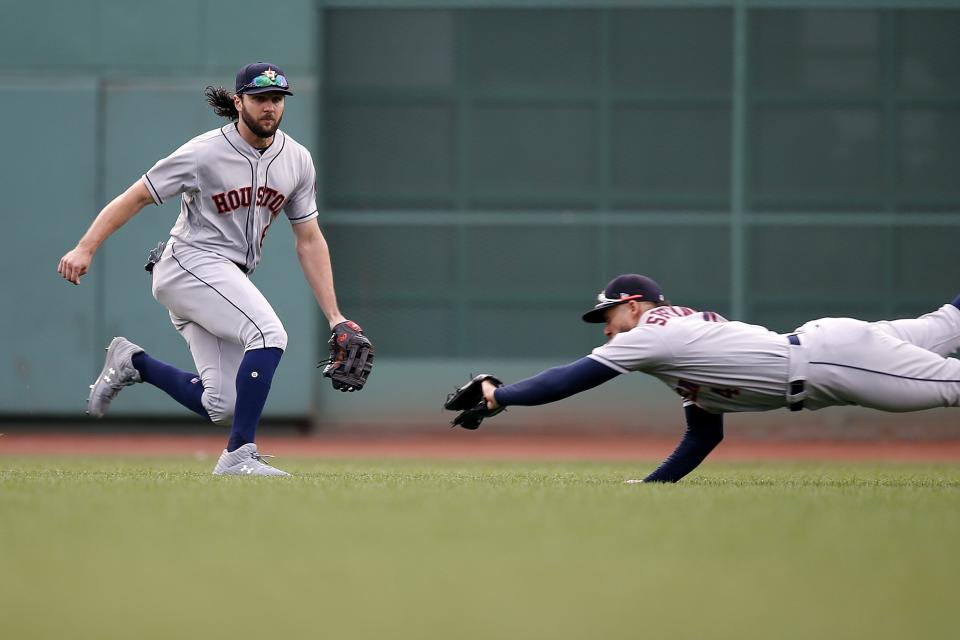 Houston Astros' George Springer, right, makes the catch in front of Jake Marisnick on the line out by Boston Red Sox's Mitch Moreland during the first inning of a baseball game in Boston, Saturday, Sept. 8, 2018. (AP Photo/Michael Dwyer)