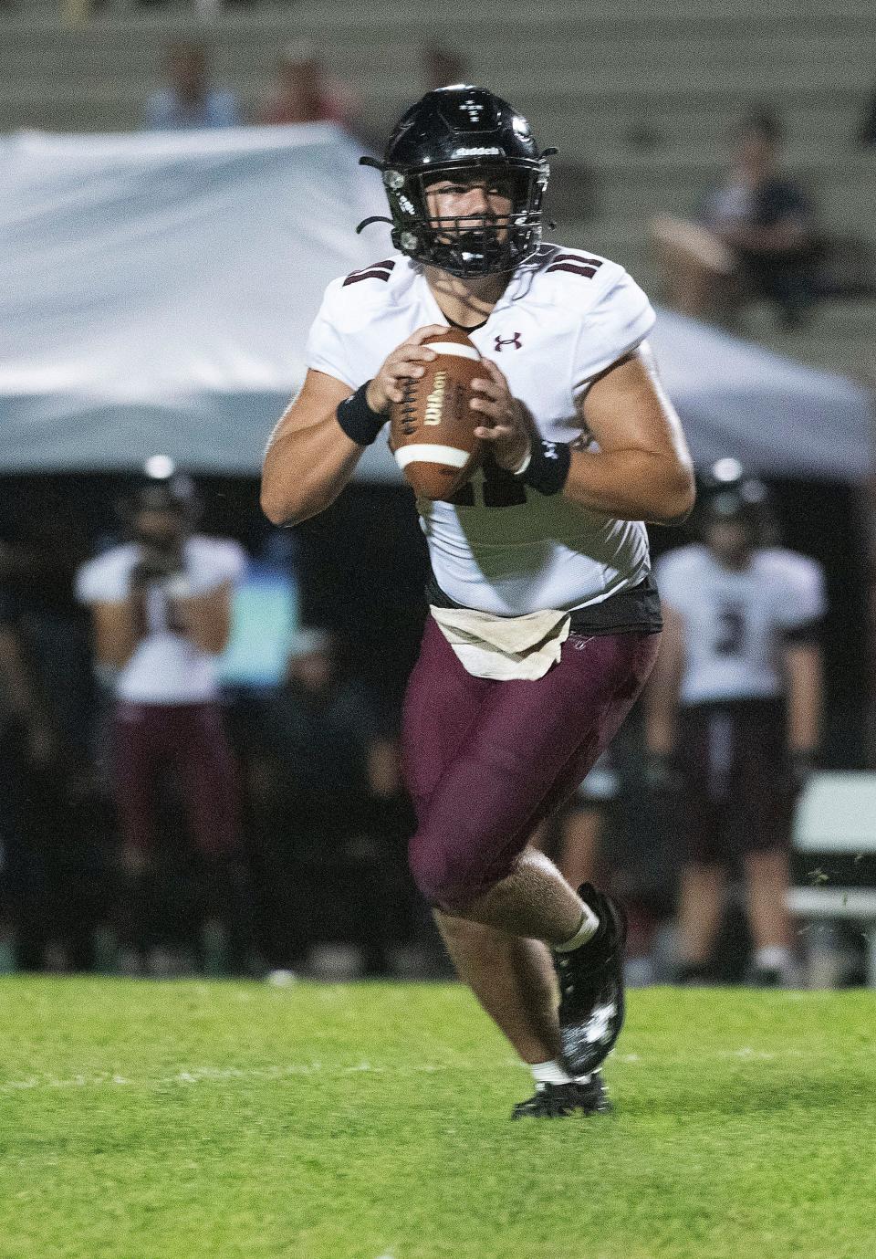 Navarre quarterback Hunter Pfiester (No. 11) scrambles out of the pocket as he looks for an open receiver during Friday's game against Pine Forest.