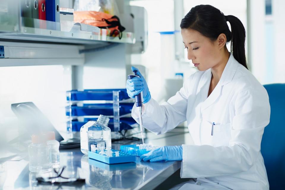 Scientist injecting samples into test tubes.