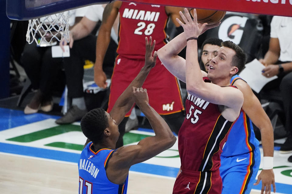 Miami Heat guard Duncan Robinson (55) shoots between Oklahoma City Thunder guard Theo Maledon, left, and guard Kenrich Williams, right, in the second half of an NBA basketball game Monday, Feb. 22, 2021, in Oklahoma City. (AP Photo/Sue Ogrocki)