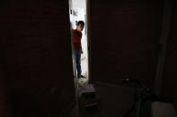 A young man quarantined in his apartment with symptoms consistent with COVID-19, opens the door to receive a delivery of medical and food supply kits dropped off by city workers, in the Coyoacan district of Mexico City, Thursday, April 9, 2020. To help halt the spread of the new coronavirus, the Mexican megalopolis is making home deliveries to households with a symptomatic person, providing kits containing food staples, face masks, gloves, antibacterial gel, paracetamol, a thermometer, and benefits cards with a balance of 1000 pesos (around $42). (AP Photo/Rebecca Blackwell)