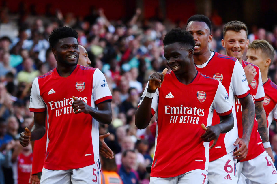 Arsenal's Bukayo Saka (right) celebrates scoring their third goal against Tottenham with teammates. 