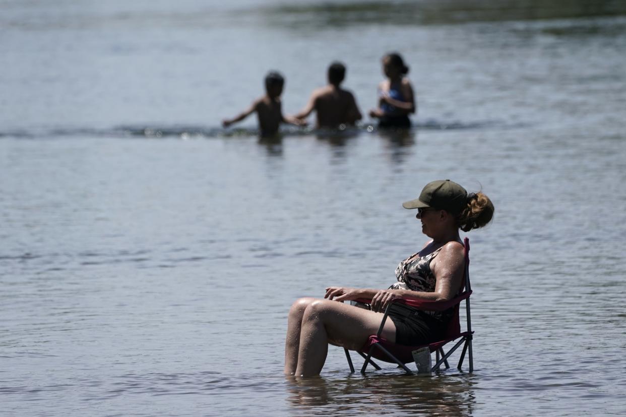 Dianna Andaya, relaxes in the cooling water of the American River as the temperature climbed over the 100 degree mark in Sacramento, Calif., Friday, June 10, 2022.