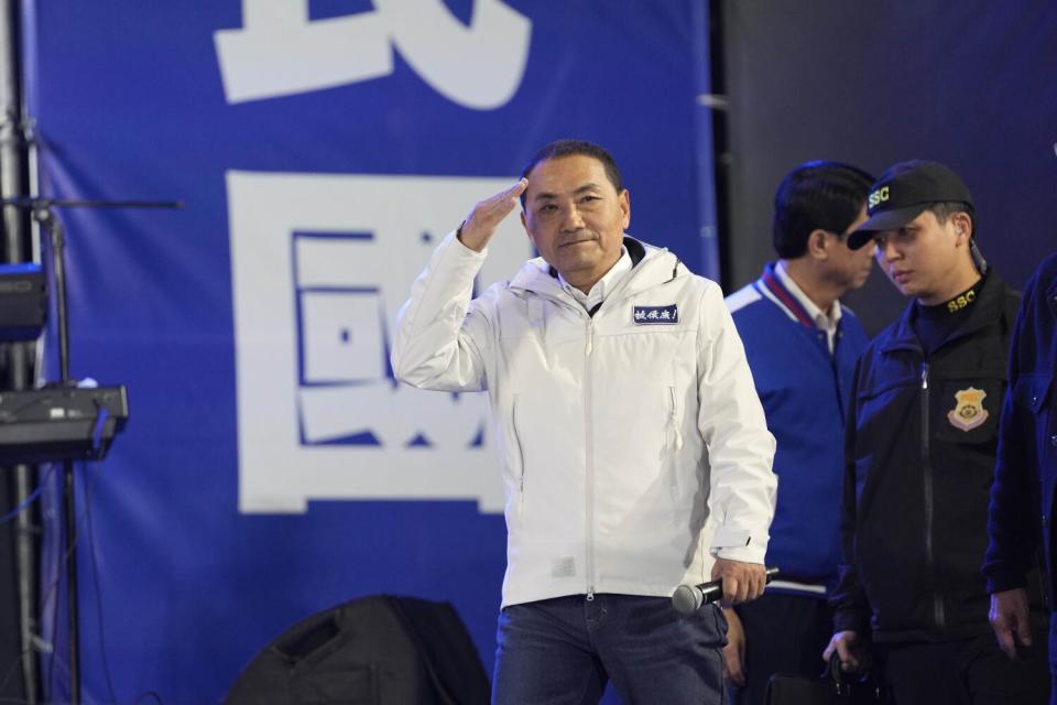 Taiwanese opposition party presidential candidate Hou Yu-ih holds his hand next to his forehead