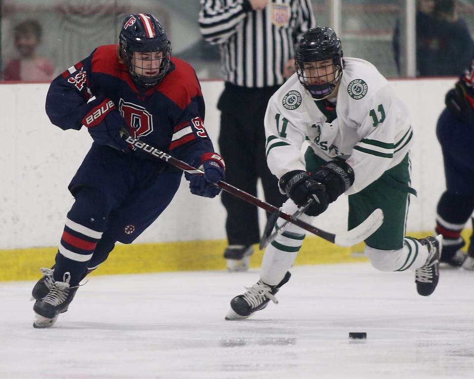 Pembroke’s Brandon Perry and Marshfield’s Matthew Garland battle for the puck at The Bog Ice Arena in Kingston on Wednesday, Feb. 15, 2023.