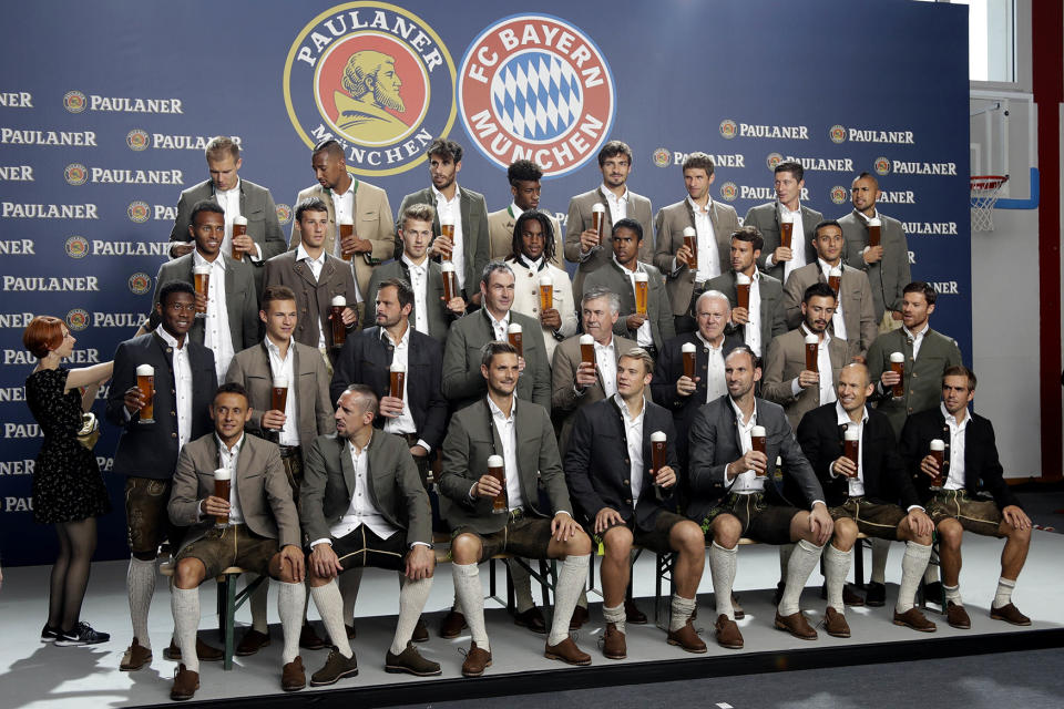 FC Bayern Munich pose with beer and wearing traditional Bavarian clothes