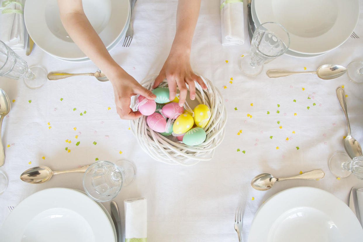 Little girl decorating dining table with Easter eggs (Westend61 / Getty Images )