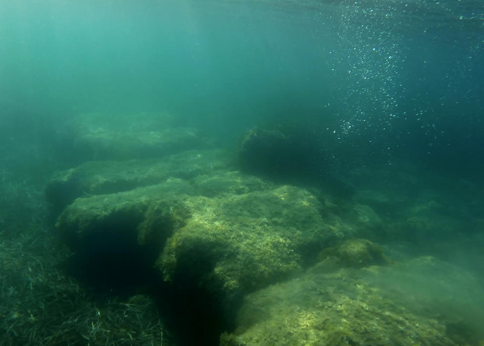 Submerged stone remains of the ancient harbor next of Amathus ancient city, in the eastern Mediterranean island of Cyprus, on Thursday, July 1, 2021. Lying just a few feet underwater a mere 200 feet off the coastline near the resort town of Limassol, this 2,400 year-old harbor said to be built Alexander the Great's successors will soon be Cyprus' newest tourist attraction where adventurous holidaymakers could snorkel over its submerged stone remains. (AP Photo/Petros Karadjias)