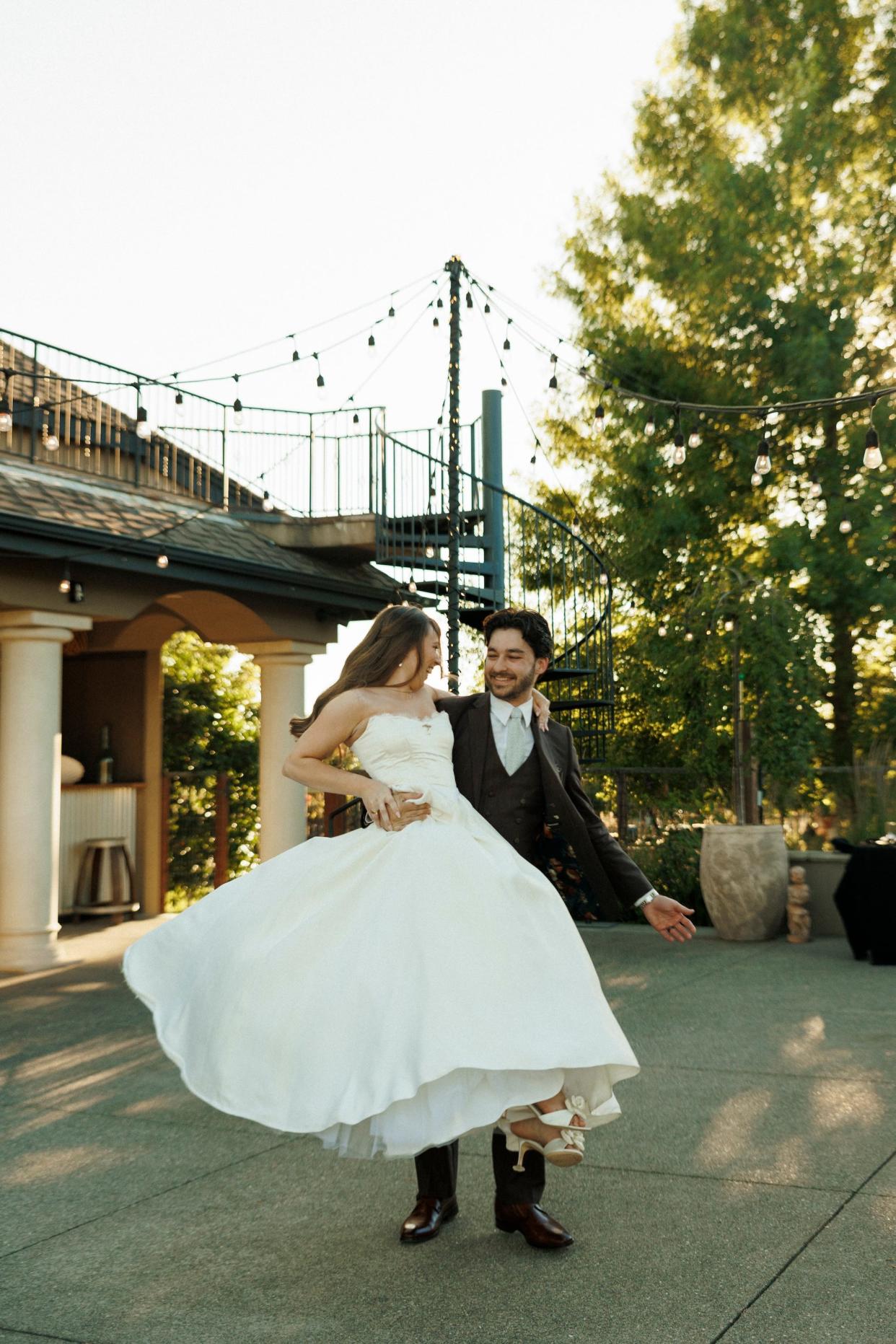 A bride and groom dance together at their outdoor wedding.