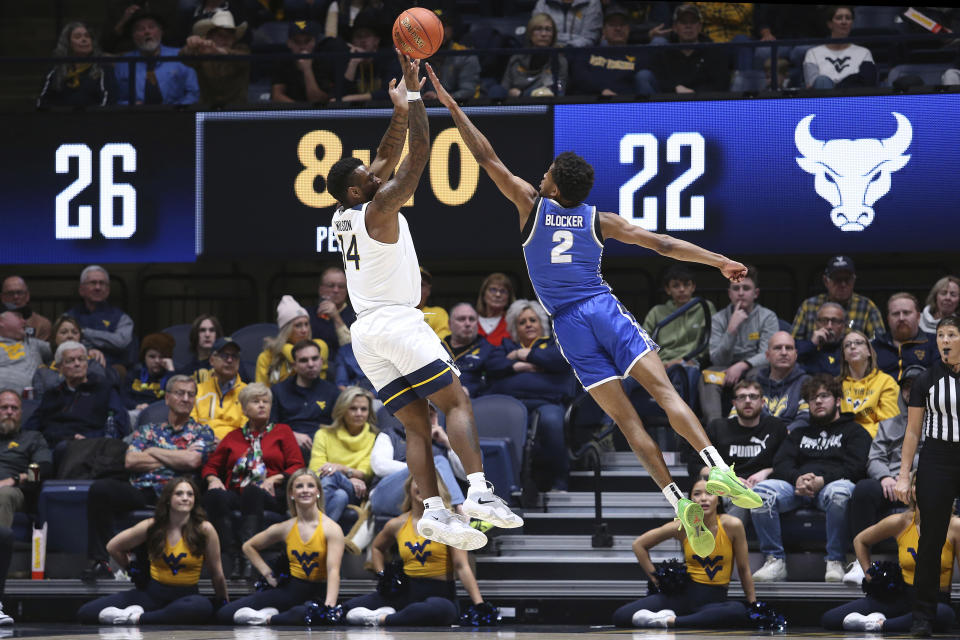 West Virginia guard Seth Wilson (14) shoots while defended by Buffalo guard Kidtrell Blocker (2) during the first half of an NCAA college basketball game in Morgantown, W.Va., Sunday, Dec. 18, 2022. (AP Photo/Kathleen Batten)