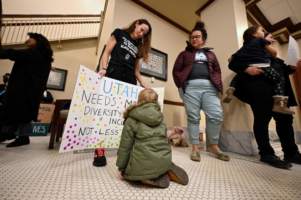 Jocelyn Akwenye holds a sign open for Owen Brough to look at as a group gathers outside the hearing room prior to Senate members of the Education Standing Committee hearing comments on HB261 at the Capitol in Salt Lake City on Monday, Jan. 22, 2024. The bill received a favorable recommendation. | Scott G Winterton, Deseret News