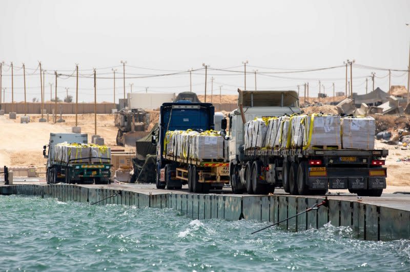 Trucks loaded with humanitarian aid from the United Arab Emirates and the United States Agency for International Development cross the Trident Pier before entering the beach in Gaza in May. File Photo via U.S. Army/UPI