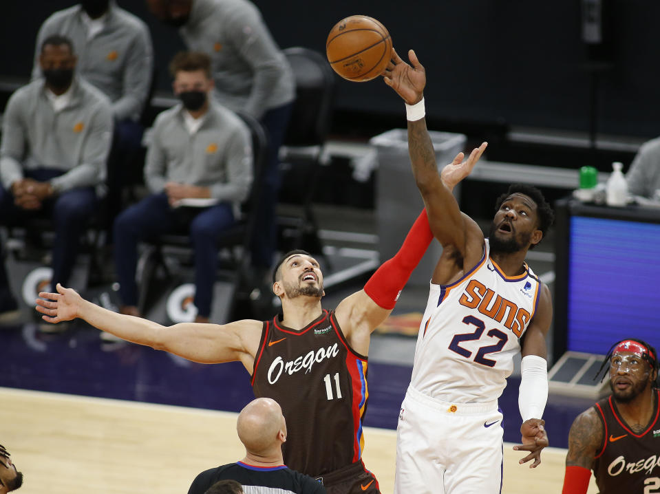 Phoenix Suns' Deandre Ayton wins the tip-off against the Portland Trail Blazers' Enes Kanter during the first half of an NBA basketball game Monday, Feb. 22, 2021, in Phoenix. (AP Photo/Darryl Webb)