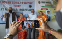 Elderly Indians stand for a photograph after receiving the COVID-19 vaccine at a private hospital in Gauhati, India, Thursday, March 4, 2021. The COVID-19 vaccination drive for senior citizens and those above 45 years of age with comorbidities began in government and designated private hospitals in Gujarat on Monday along with the rest of the country. (AP Photo/Anupam Nath)