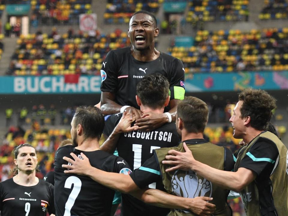 Austria captain David Alaba (top) celebrates with his team-mates (POOL/AFP via Getty Images)