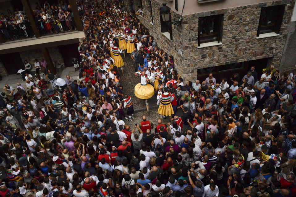 <p>People surround dancers as they perform on stilts in honor of Saint Mary Magdalene in a street for the traditional “Danza de Los Zancos” (Los Zancos Dance), in the small town of Anguiano, northern Spain, July 23, 2016. (AP Photo/Alvaro Barrientos)</p>